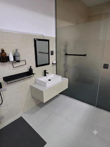 a bathroom with a sink and a mirror and a shower at Hotel Velmont Kandy in Kandy
