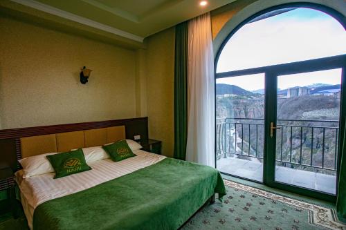 a bedroom with a bed and a large window at Nairi Hotel in Jermuk