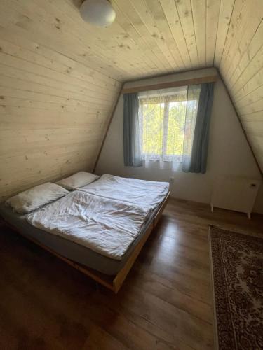 a bedroom with a bed in a room with a window at Chata Buková in Brezina