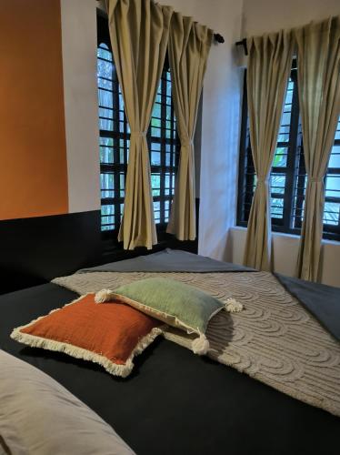 a bedroom with two beds with windows at Mad about Coco Yoga & Beach Retreat in Varkala
