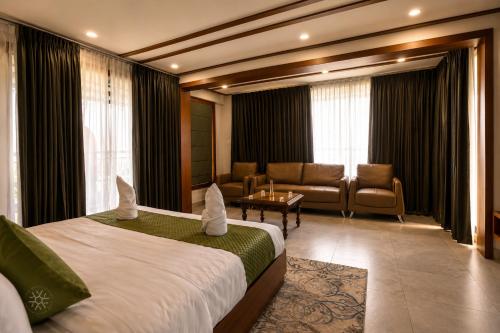 a hotel room with a bed and a couch at Ynad Mount Resort in Meppādi
