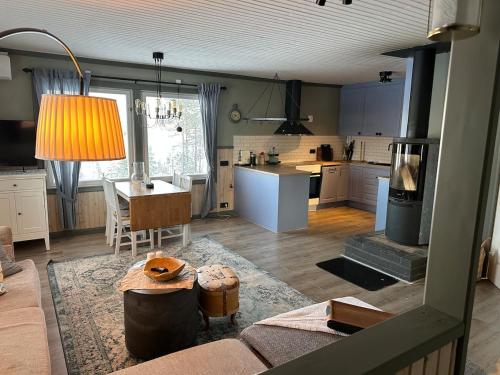 a kitchen and living room with a table and a stove at Fishermans luck in Arvidsjaur