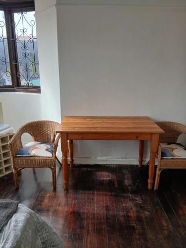 a wooden table and two chairs in a room at Jacqui's abode in Kirstenhof