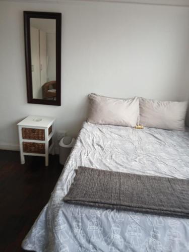 a bedroom with a bed with a mirror on the wall at Jacqui's abode in Kirstenhof