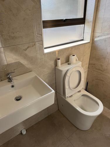 a bathroom with a toilet and a sink and a mirror at Highveld Nook in Sasolburg