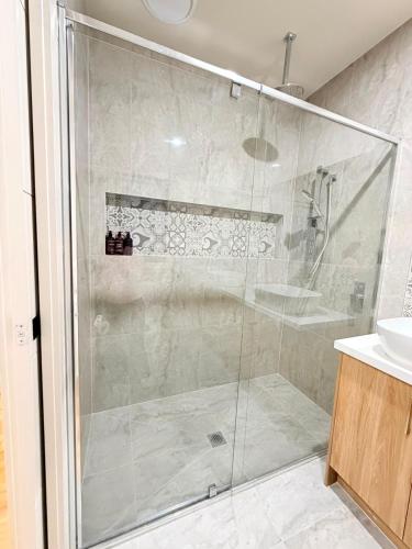 a shower with a glass door in a bathroom at Grand Suite with Ensuite Bathroom in Wyndham Vale