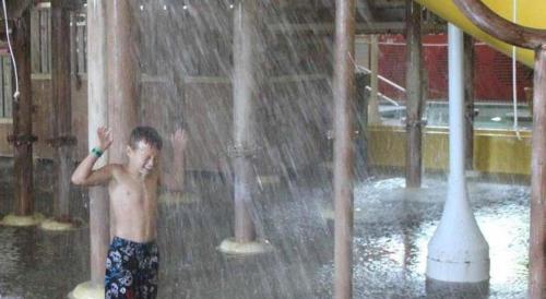 a young boy standing in a water fountain at Tan-Tar-A Estates in Damsel