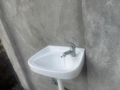 a bathroom sink with a faucet on a wall at Fireworks bungalows in White Sands