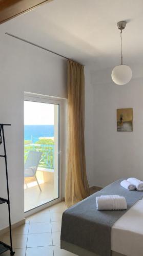 a bedroom with a bed and a view of the ocean at Velmare apartments in Paralia Vrachou