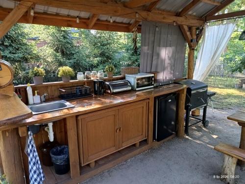 an outdoor kitchen with a counter and a sink at Wood Camping in Brochów