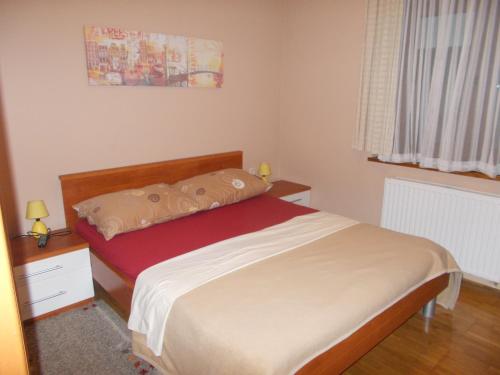 um pequeno quarto com uma cama e uma janela em Guesthouse Ivancica em Našice