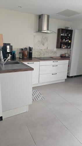 a kitchen with white cabinets and a counter top at Au bord de La Boëme in Mouthiers-sur-Boëme