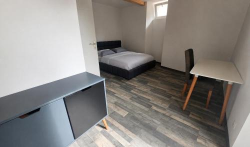 a small room with a bed and a desk at Au bord de La Boëme in Mouthiers-sur-Boëme