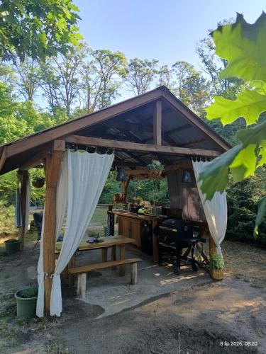 a wooden pergola with a table and a desk at Wood Camping in Brochów