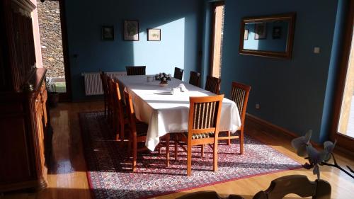 a dining room with a white table and chairs at Gospodarstwo Agroturystyczne-Pensjonat SAD in Podgórzyn