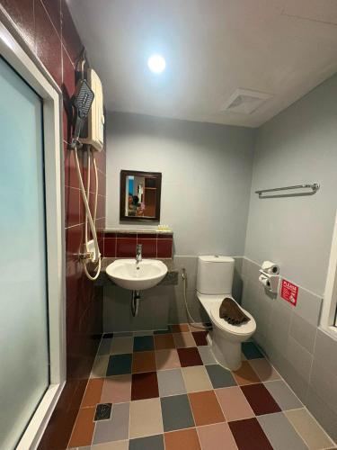 a bathroom with a toilet and a sink at PorterHouse Beach Hotel in Patong Beach