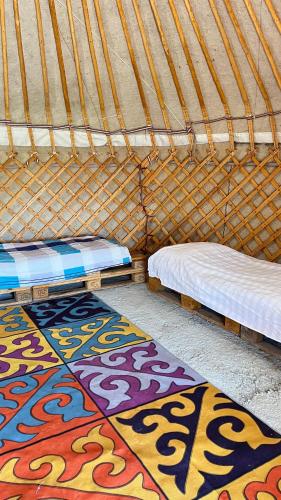 two beds in a yurt with mats on the floor at ЭКО балык Седеп юурт 