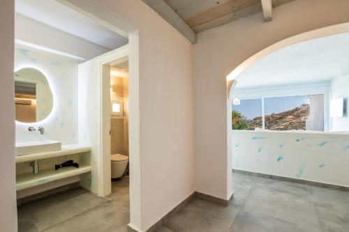 a bathroom with a sink and a toilet and a window at Poseidon Blue Gastronomy Hotel in Afiartis
