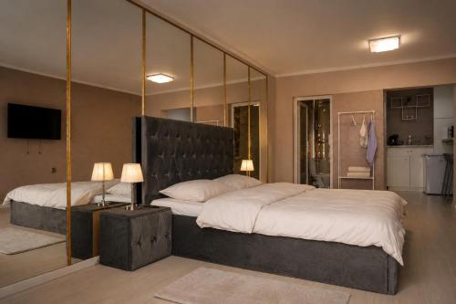 a bedroom with a large bed and a mirror at Azur House in Cluj-Napoca