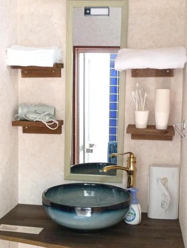 a bathroom with a blue sink and a mirror at ただいまtadaima in Yahata