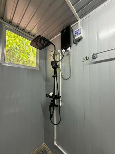 a shower in a bathroom with a lamp on the wall at TAGBALAYON-GARDEN Guest House in Siquijor