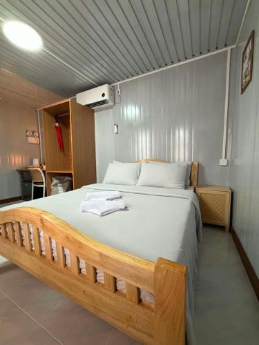 a bedroom with a large bed with towels on it at TAGBALAYON-GARDEN Guest House in Siquijor