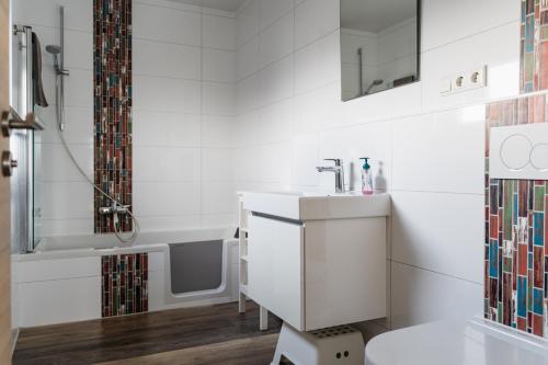 a white bathroom with a sink and a bath tub at Seelenruhe in Goch