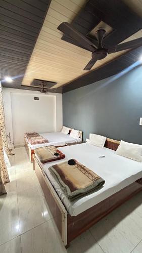 two beds in a room with a ceiling fan at The MEERA in Godarpura