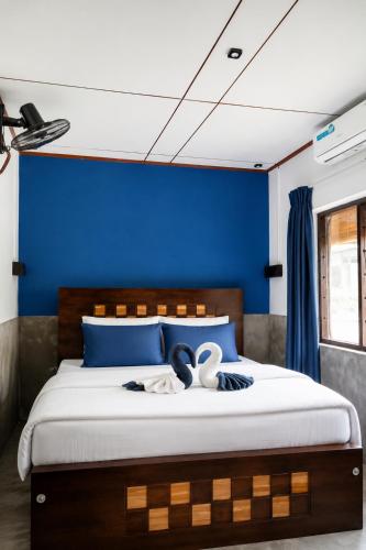 a bedroom with a bed with a blue wall at 87 Ahangama in Ahangama