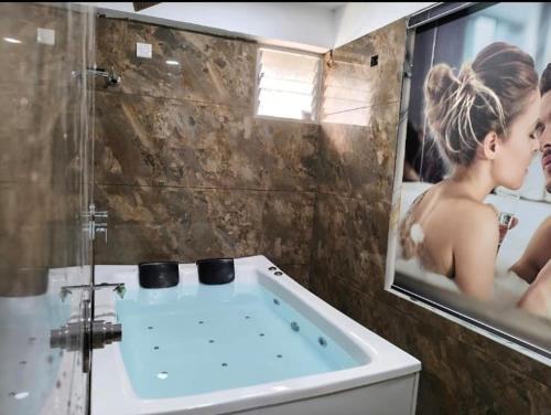 a bathroom with a tub with a woman in a mirror at Hotel J K Town in Ahmedabad