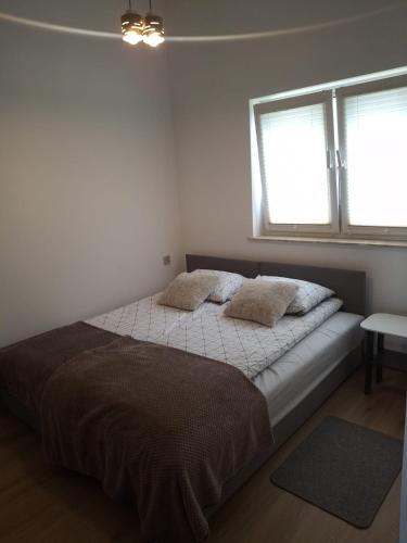 a bedroom with a bed with two pillows on it at Nowy Zakątek in Paszkówka
