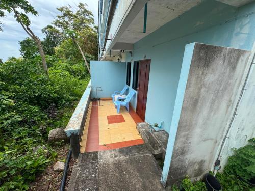 a blue house with a bench and a chair at Tommy Apartment - main road in Ko Tao