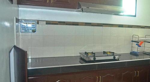 a kitchen with a stove top on a counter at Mayon Backpackers Hostel in Legazpi