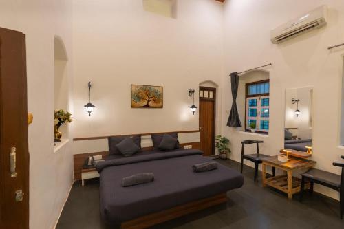 a bedroom with a bed and a living room at Shalimar in the Forest in Matheran