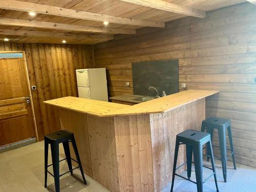 a kitchen with a counter and stools in a room at La Bohème aux wallabies in Pajay