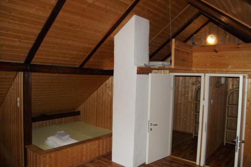 Zimmer im Dachgeschoss mit einem Bett und einer Tür in der Unterkunft Villa Donkey Ferienwohnung Heustall in Degersheim