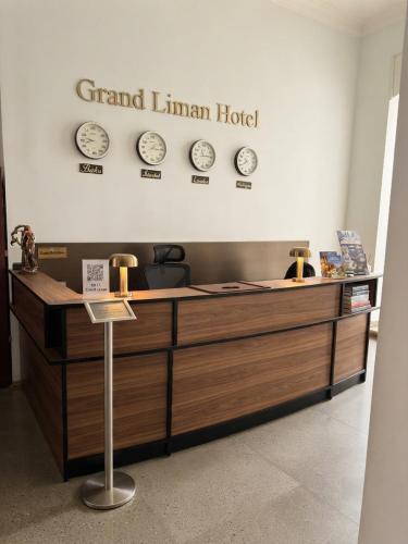 a reception desk with clocks on the wall at Grand Liman Hotel in Baku