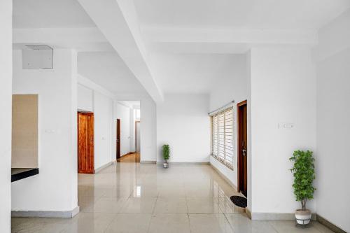 an empty hallway with white walls and plants at Hotel O Dream Marion in Bhubaneshwar