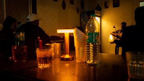 a table with glasses and a bottle of water on it at Shalimar in the Forest in Matheran