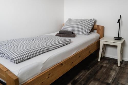 a bed with a wooden frame and a night stand at Seepark Goch-Kessel in Kessel