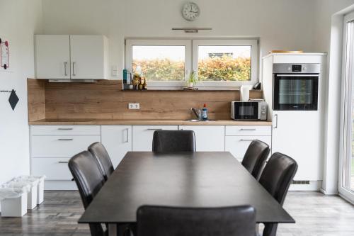 a kitchen with a black table and chairs in it at Seepark Goch-Kessel in Kessel