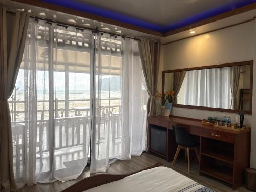 a bedroom with a mirror and a desk and a balcony at Fabregas Beach Cottages in El Nido