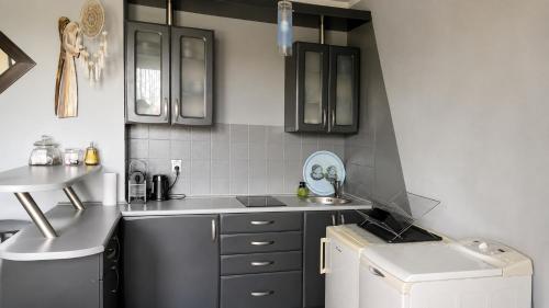 a kitchen with black and white cabinets and a sink at Duplex U Marzeny in Ostróda