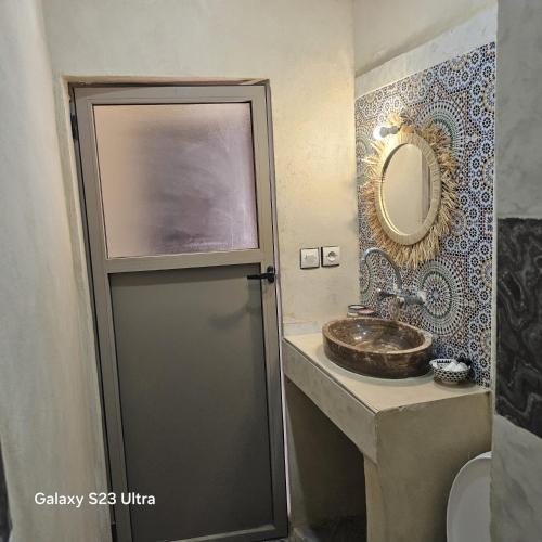 a bathroom with a sink and a mirror at Auberge Sahara Garden in Lac Yasmins