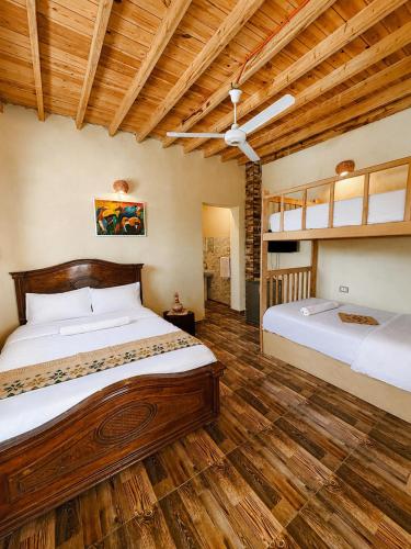 two beds in a room with wooden floors at Slow Tunis in Tunis
