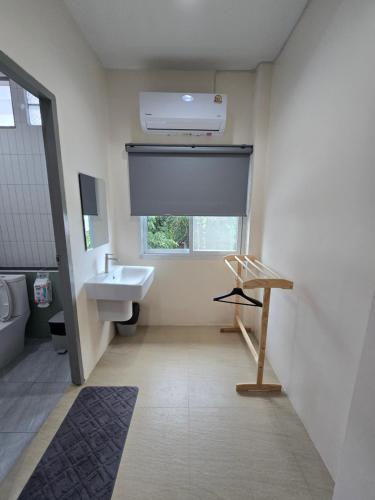 a bathroom with a sink and a toilet and a window at Buddy Hostel in Chiang Rai