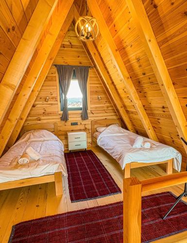 two beds in a room in a log cabin at Cottage Magdalena in Žabljak