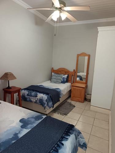 a bedroom with two beds and a ceiling fan at Unit 18 Kei Sands Resort in Kei-mouth Village