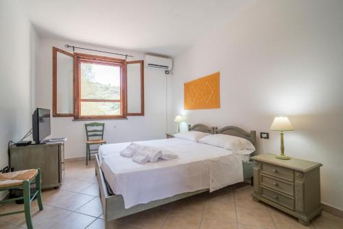 a bedroom with a bed and a television in it at Residence Hotel Monte Ricciu Nuova Gestione in Alghero