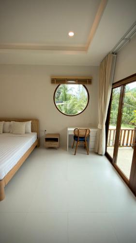 a bedroom with a bed and a window at Canal Villa in Chaloklum